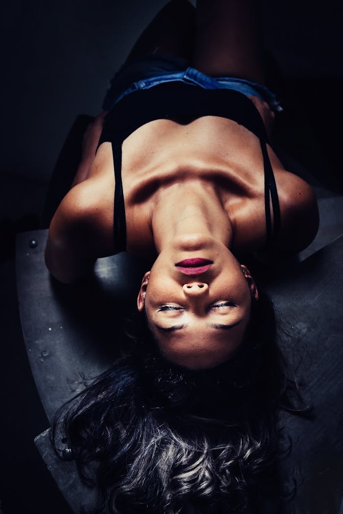 Artistic portrait featuring a woman in dramatic lighting, eyes closed, expressing elegance and sensuality.